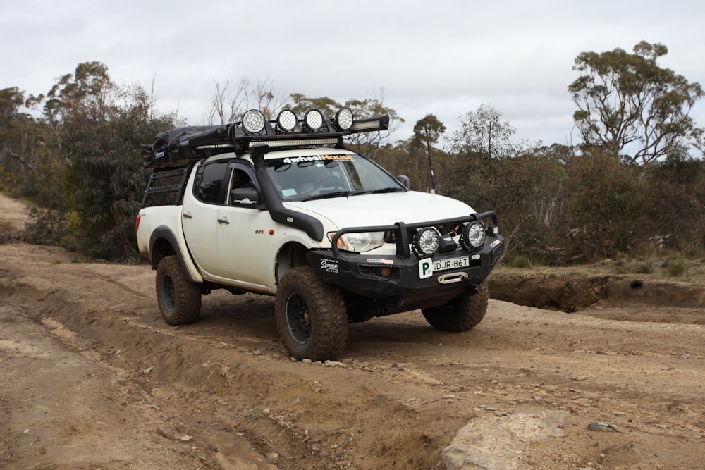 A kitted-out four-wheel drive on a rutted dirt track through the Australian bush